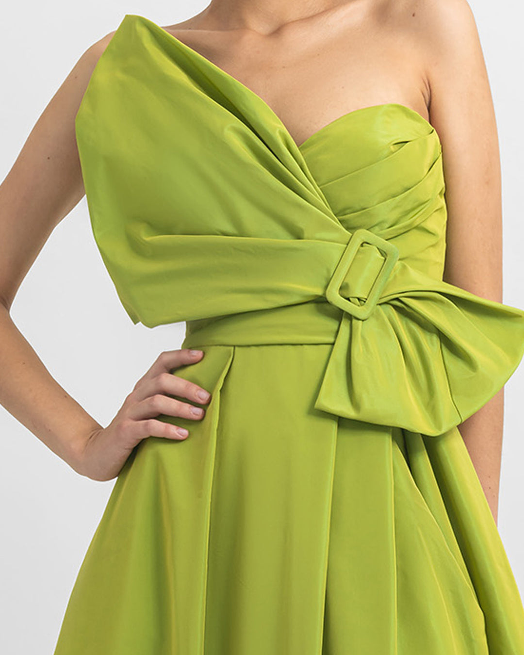 A close-up of a bow-like design, strapless Tafta green dress with open slit on the side.