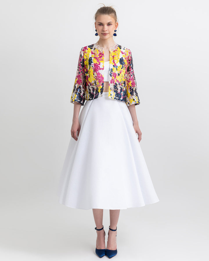 An occasion wear featuring a white cropped top paired with a multicolor sequined jacket and a flared white skirt.