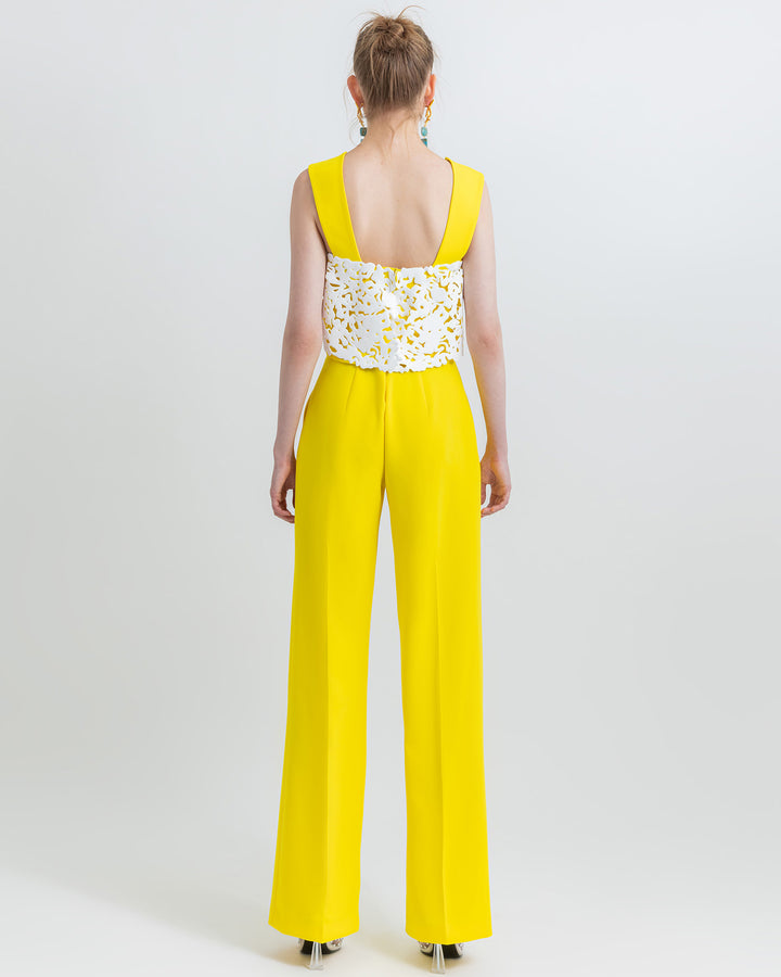 The back of an occasion wear featuring a yellow straight cut crepe pants paired with a cropped crepe top with white laser-cut silicon.