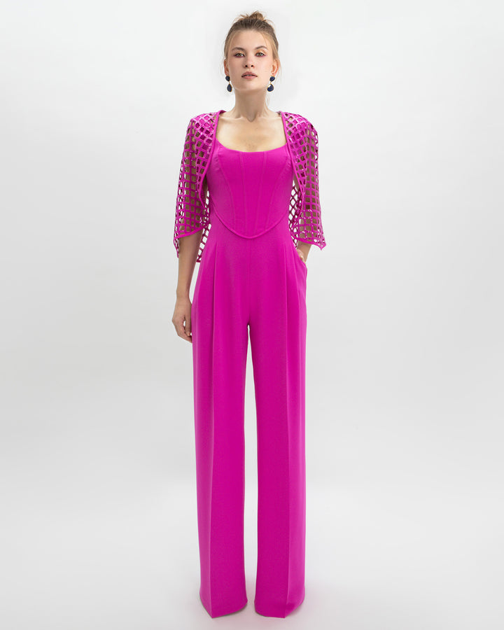 An evening wear look featuring a corset jumpsuit paired with a detachable sequined cape all in fuchsia color.