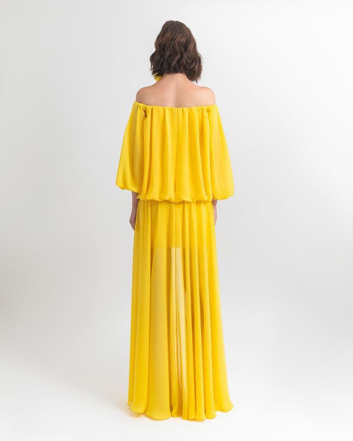 The back of an off-shoulders, loose cut chiffon yellow evening dress.