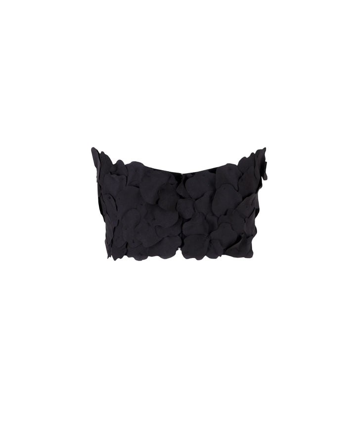 The back of a strapless black cropped-top with laser cut details.