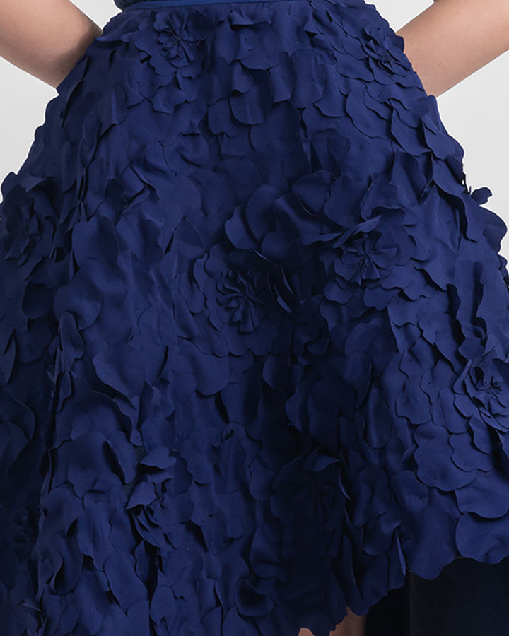 A close-up of a wide asymmetrical hemline laser-cut navy blue skirt.