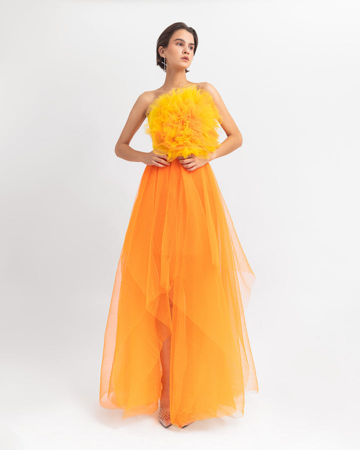 A flower draped tulle long dress with an orange fully pleated long skirt.