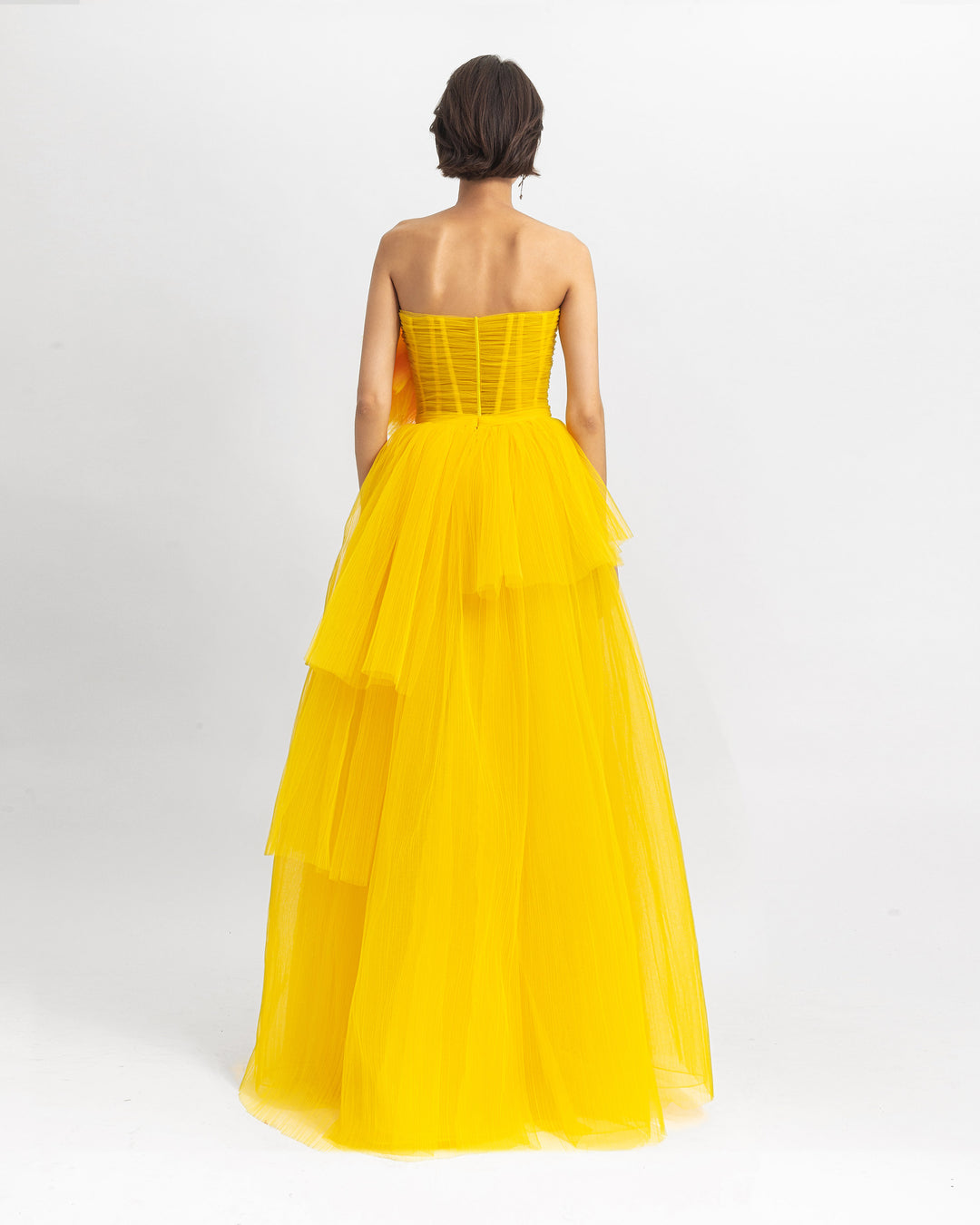 The back of draped flower corset long evening dress with a fully pleated skirt.