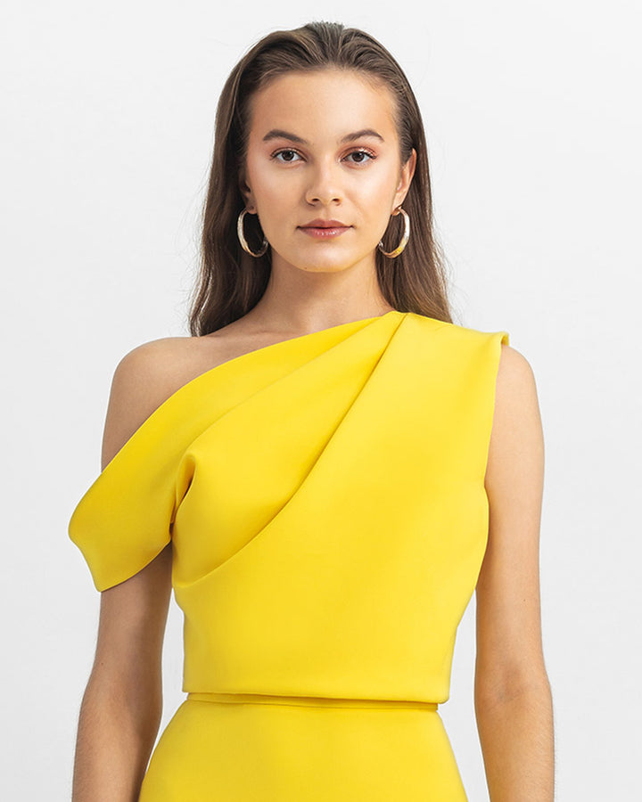 An asymmetrical cut crepe yellow top with draping details.