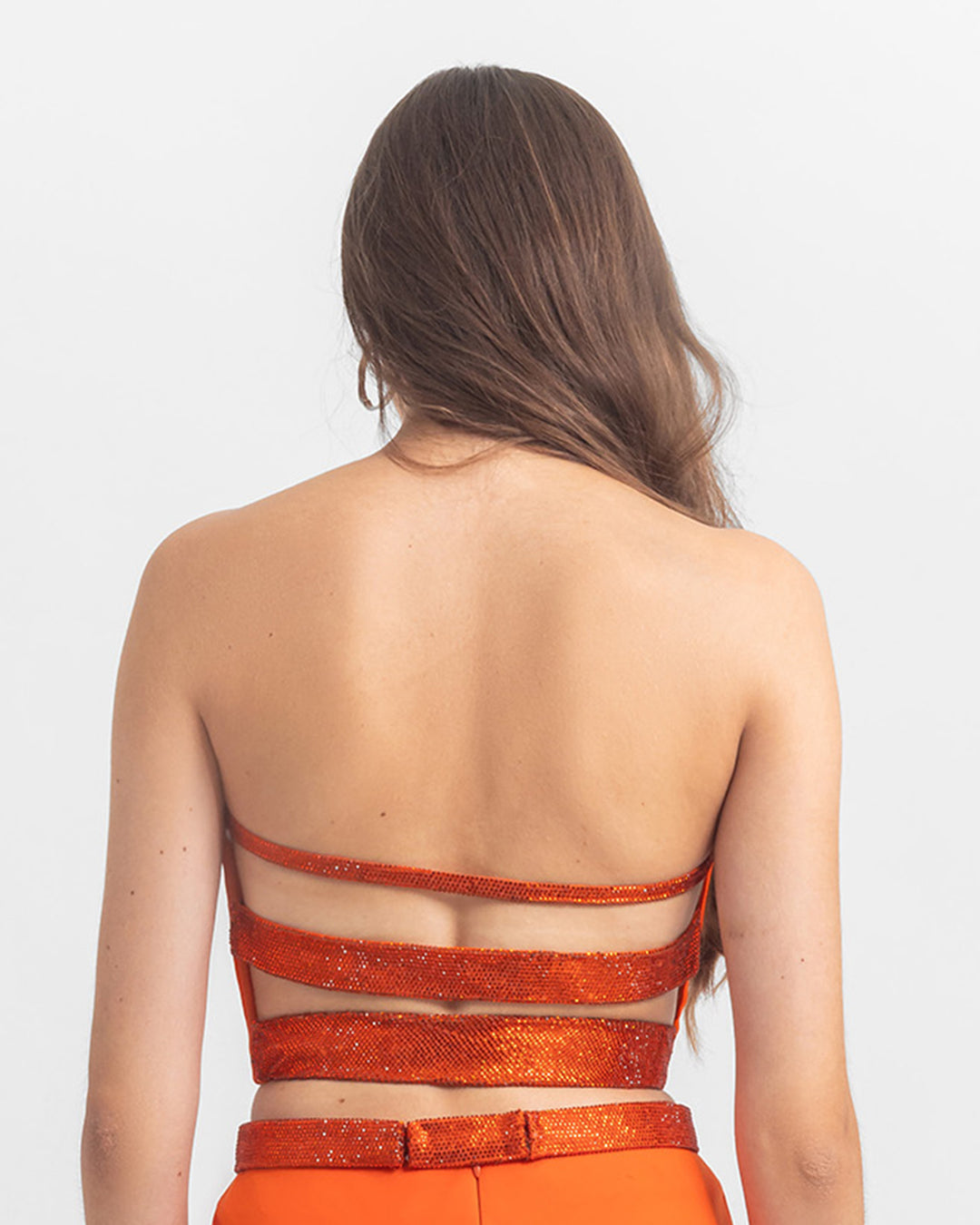 The back of a  strapless satin top with sequined strap details.