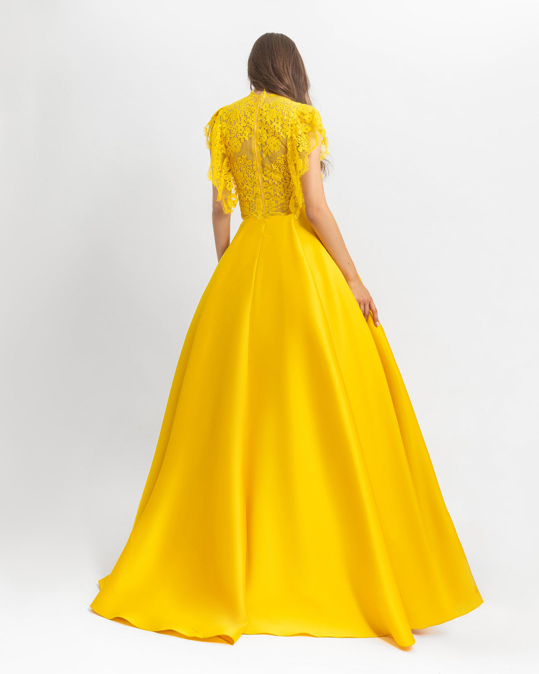 The back of a ruffled details lace top with wide cut satin yellow long evening dress.