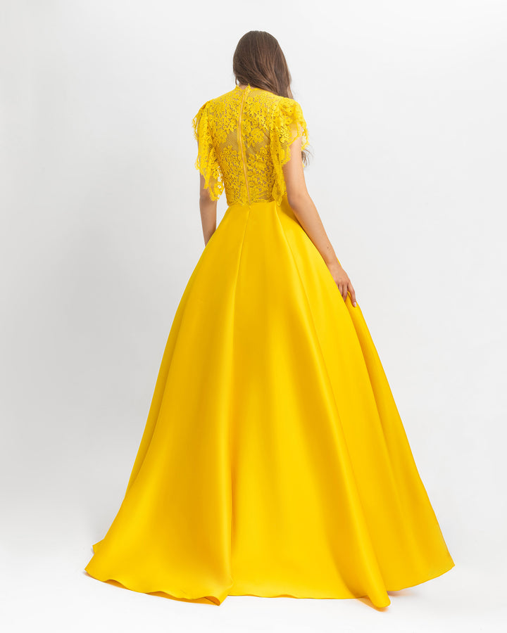 The back of a ruffled details lace top with wide cut satin yellow long evening dress.