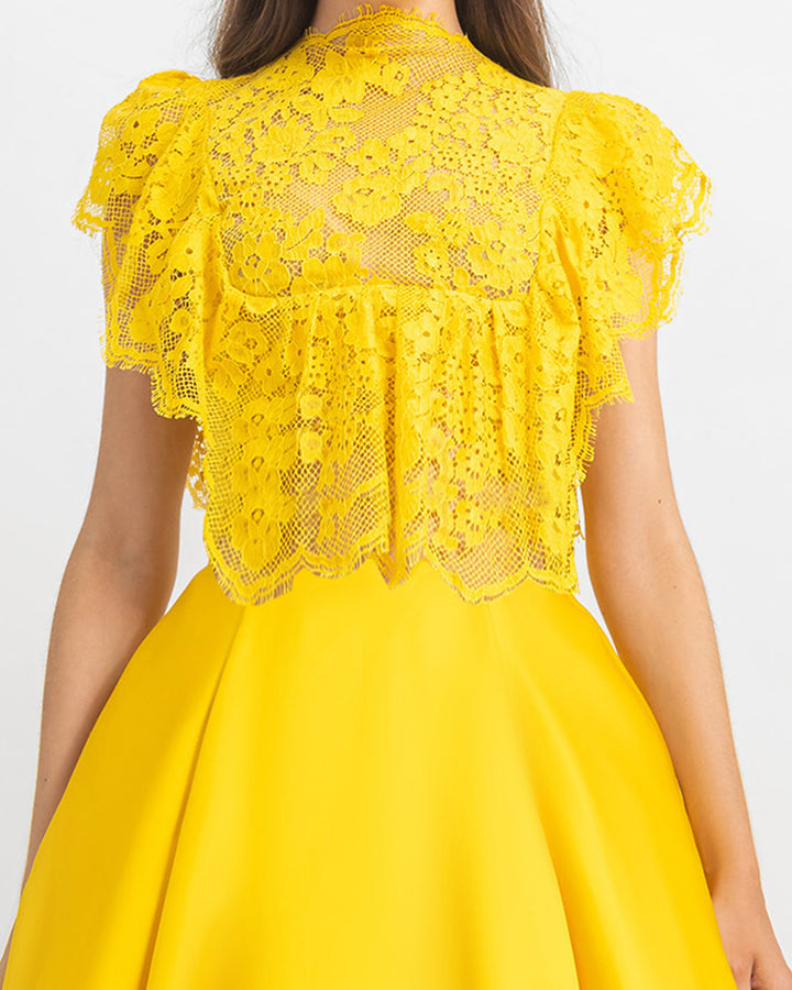 A close-up of a ruffled details lace top with wide cut satin yellow long evening dress.