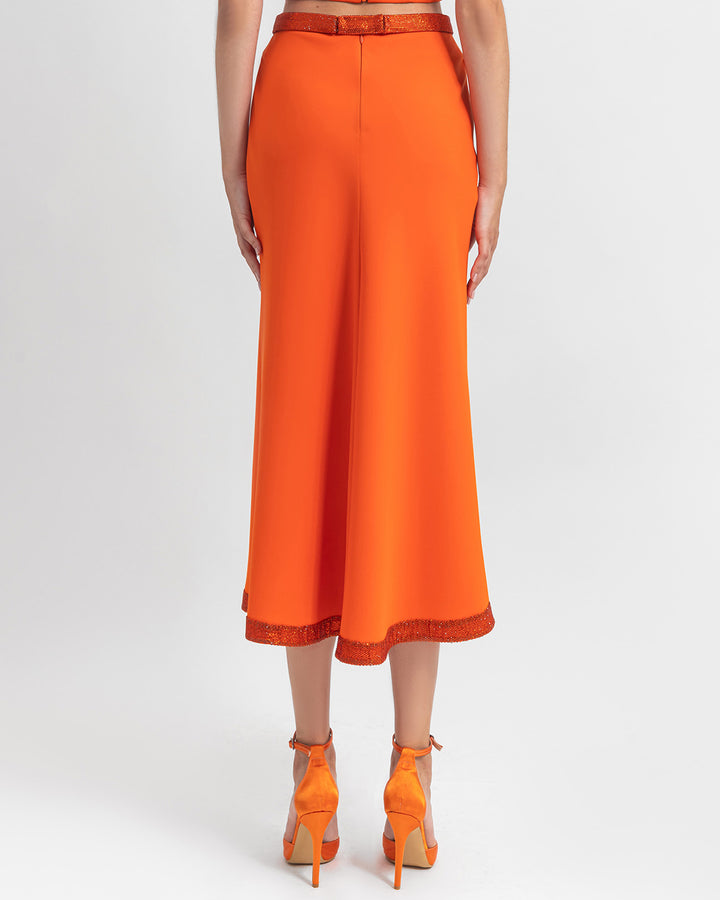 The back of a straight cut crepe orange skirt with sequin details on the waist and hemline.