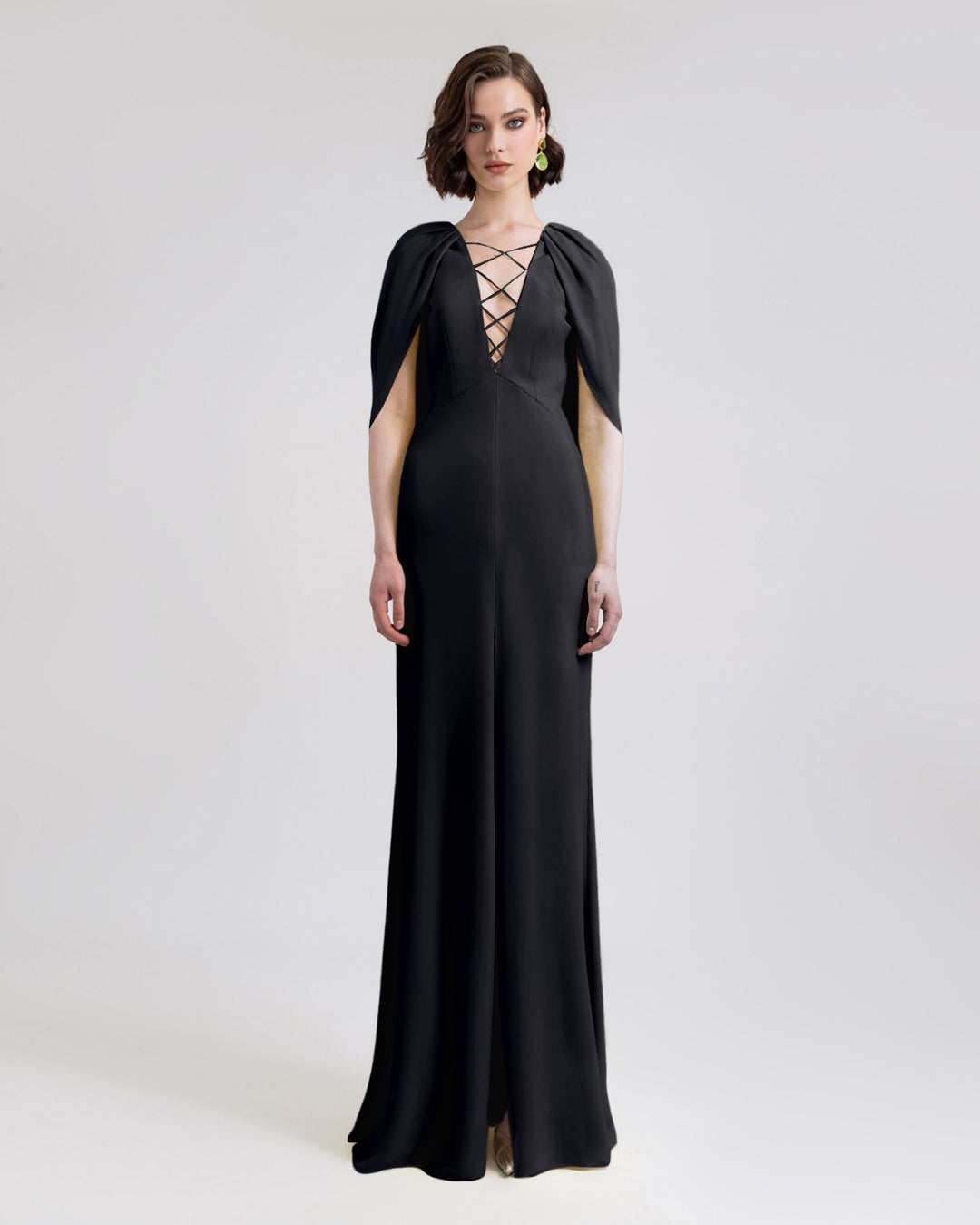 A deep V-neckline black evening dress featuring cape-like sleeves and an open slit in the middle.