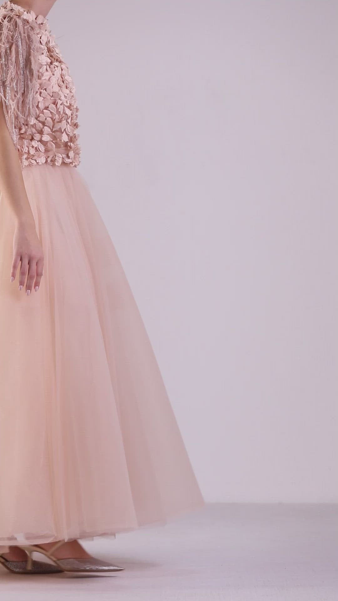 An evening wear set featuring a fully embellished folded satin on tulle top paired with a pink A-cut tulle midi skirt.